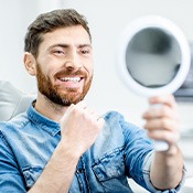 a patient checking his smile with a mirror