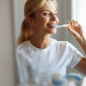 a woman brushing her teeth in the morning