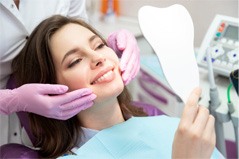 woman smiling in dental mirror