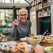Woman smiling while eating healthy meal with friend