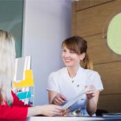 dental team member showing paper to a patient