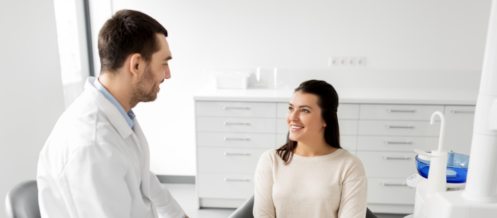 Dentist talking to smiling dental patient