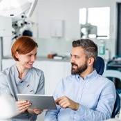 a patient discussing the cost of veneers with his dentist