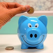 Hand putting coin in piggy bank