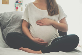 Pregnant woman holding her stomach.